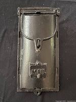 Front closed view of the black cast iron mailbox showing the MAIL label and latch mechanism