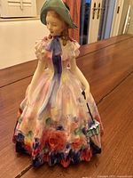 Front view of Royal Doulton Easter Day figurine showing floral dress and parasol detail.