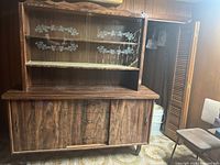 Front view of the brown veneer display cabinet with glass doors featuring a white floral design and two wood cabinet doors below
