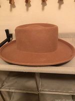 Side view of brown hat with flat brim and crown