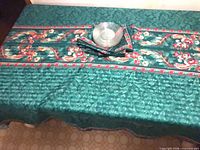 Tablecloth spread on table with stacked plates and folded napkins