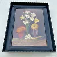 Front view of framed still life painting showing daffodils and fruit under glass.