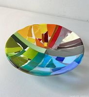 Top angled view of fused glass bowl displaying the vibrant color mosaic including yellow, orange, green, blue, red, gray, and cream glass pieces.