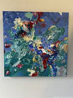 Front view of square abstract oil painting showcasing multi-colored heavy textured brushstrokes on canvas.