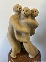 Front angle view of modernist three figure sculpture showing texture and facial details