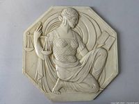 Full view of the octagonal chalkware wall plaque featuring a kneeling woman holding scales and an open book.