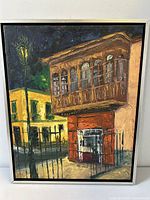 Front view of the framed oil painting showing city buildings and street lamp at night with thick textured brushstrokes.