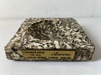 Front view showing the granite texture, inset round bowl, and label indicating origin from Old London Bridge.
