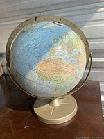 12-inch diameter world globe showing continents including Africa and Europe, mounted on metal base with meridian ring.