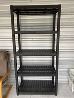 Front-facing view of the black plastic five-shelf storage unit showing overall structure and shelf spacing.