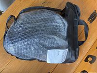 Black mesh carrying bag for the snorkel mask with label showing size S-XL