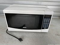 Front view of RCA white microwave oven showing keypad panel and plug.