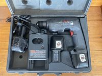 Overview of Skil cordless drill set in carrying case including drill, charger, and two batteries showing wear.