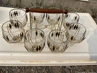 Set of 8 vintage cocktail glasses arranged in metal carrier with wooden handle, showing argyle pattern on glasses