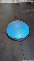 Blue BOSU Balance Trainer dome with concentric circular ridges on gym floor.