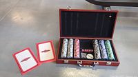 Open wood poker case with five stacks of chips, two decks of cards, poker rules booklet