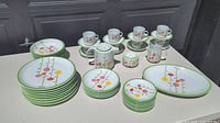Wide view of all plates, bowls, cups and saucers arranged on table