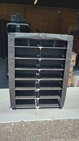 Front view of the medium black portable storage rack displaying two columns of six shelves each with black fabric cover and zipper at top.