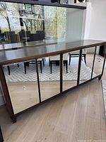 Front view of credenza showing five mirrored doors and overall silhouette