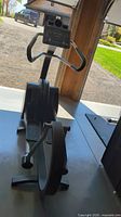Front view of elliptical trainer showing console display and foot pedals