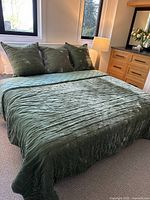 Photo of bed made with three green European pillows and the green side of the king size reversible coverlet.