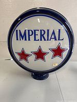 Front view of single-sided glass globe with "IMPERIAL" lettering and three red stars