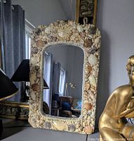 Front view of rectangular mirror showing full seashell‐encrusted frame