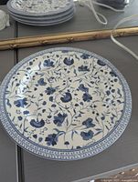 Single close-up photo of a Ralph Lauren Macao pattern salad plate showing blue floral design and detailed rim.