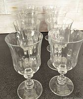 Set of eight clear crystal Mikasa French Countryside iced tea glasses arranged in two rows on a dark surface.