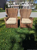 Front view of both chairs on grass showing woven seagrass frames and beige cushions