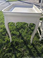 Photo of entire tray table showing curved legs and raised edge tray top.