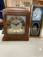 Wooden Bulova mantel clock with brass and gold accents, Roman numeral dial, showing front view