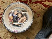 Front view of decorative plate showing image of two girls, teddy bear, photo album, and inscription text.