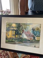 Full view of framed painting depicting Quebec homesteads in a landscape setting, held for scale.