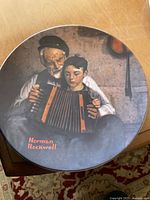 Front view of the collectible plate showing the detailed Norman Rockwell artwork of an elderly man and boy with an accordion with signature in red.