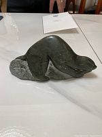 Soapstone seal sculpture on white surface showing shape and details of the artwork.