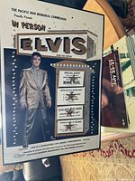 Photo of vintage reproduction poster showing Elvis Presley in suit and event details for Block Arena Pearl Harbor March 25