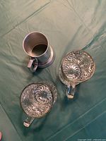 Top-down view showing the two glass beer mugs with starburst pattern on base and metal beer mug interior.