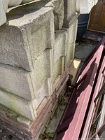 Stack of concrete cement blocks with weathering and moss visible.
