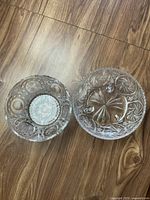 Top view of two etched crystal bowls showing detailed circular and starburst patterns.