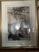 Framed art print showing a boy and girl standing near a planter with greenery, housed in a gold-toned ornamental frame with white matting.