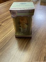 Photo of the front of the Precious Moments resin figurine inside original box showing the figurine of a girl holding a heart and the sign 'I missed you'.