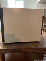 Side view of the vintage Quasar microwave showing the off-white casing and black side panel.