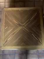 Top down view of wooden coffee table showing intricate wood grain pattern with chevron designs.