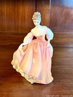 View of Royal Doulton 'Fair Lady' figurine showing front detail and pink flowing gown.