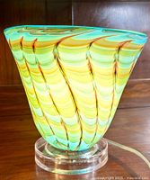 Front-left view of hand blown glass lamp on wood surface