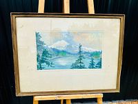 Framed vintage landscape oil painting on easel, under glass with wooden frame.