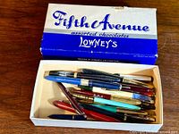 Old Fifth Avenue assorted chocolates box containing vintage pens.
