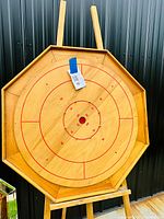 Full view of the octagonal wooden Crokinole board showing the playing surface and scoring rings.
