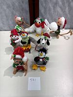 Eight felt Christmas animals arranged on white surface, showing full lot.